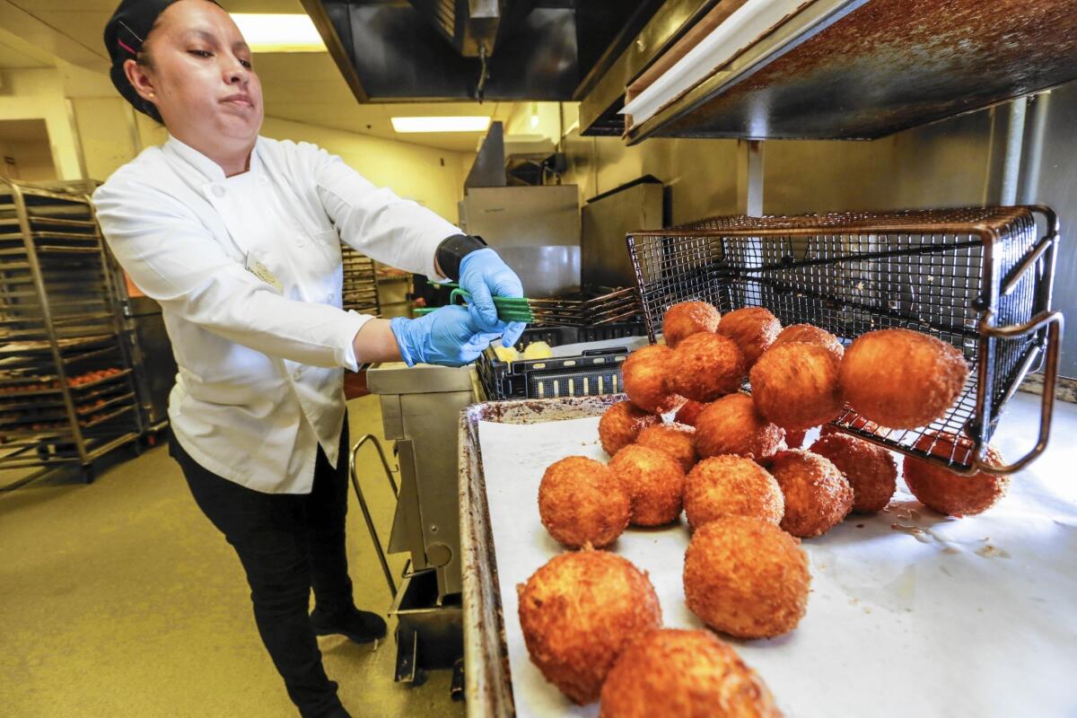 Mara Serrano fries potato balls at Porto's Bakery & Cafe in Glendale. In March, the chain dished out nearly 520,000 potato balls in its three locations.