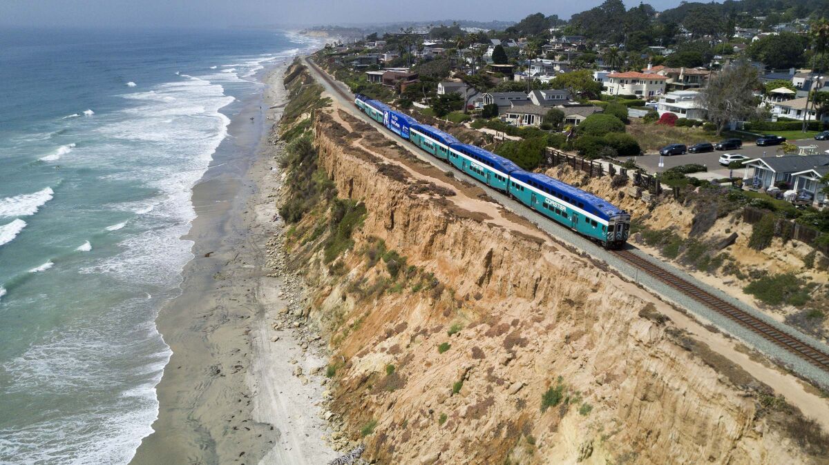 A Surfliner train by Amtrak travels along the collapsing bluffs in Del Mar, where sea levels are rising due to climate change.