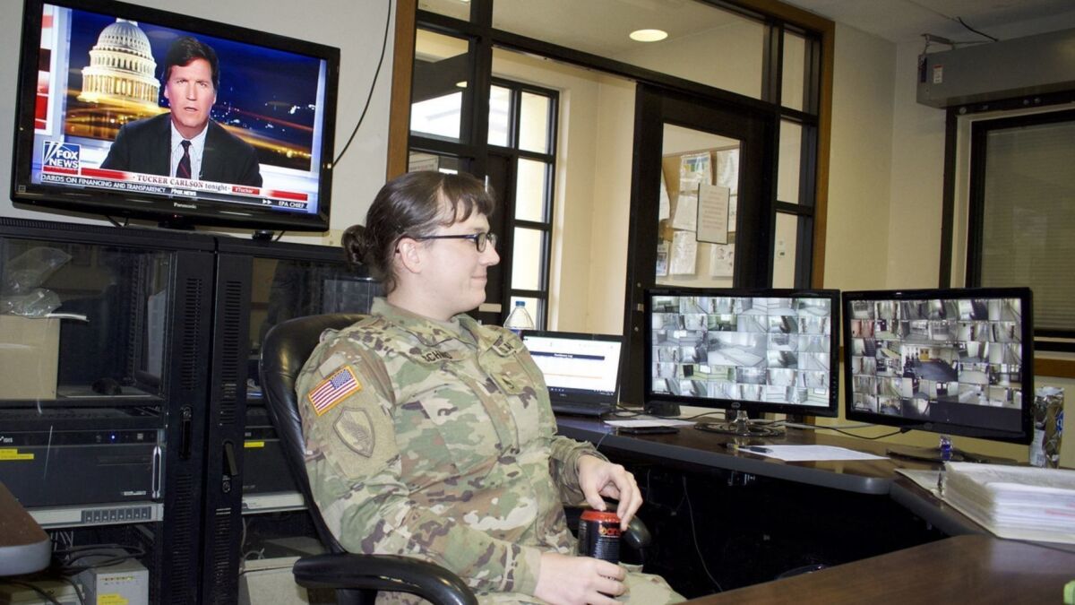 Army Staff Sgt Cathrine Schmid is on all-night duty in March, sitting at the front desk of her barracks at Camp Humphrey in South Korea. (Photo Credit: David Cloud/ Los Angeles Times)