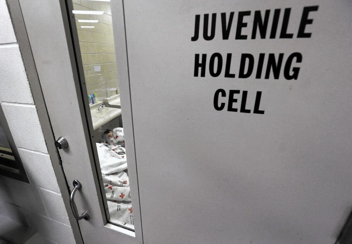 A detainee sleeps inside a holding cell at a U.S. Customs and Border Protection processing center in Brownsville, Texas.