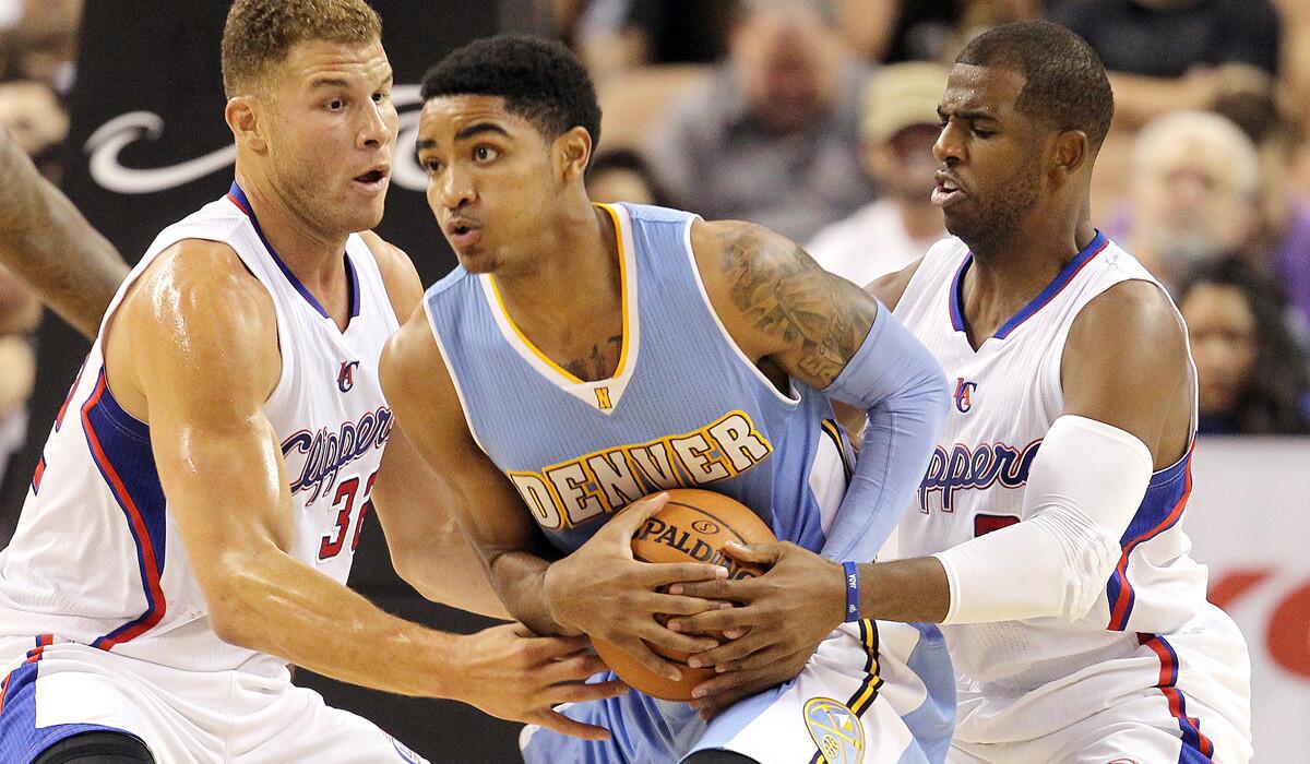 Clippers All-Stars Blake Griffin, left, and Chris Paul, shown trying to steal the ball from Nuggets guard Gary Harris during a preseason game, could play fewer minutes than usual to start the season because of a rugged early schedule.