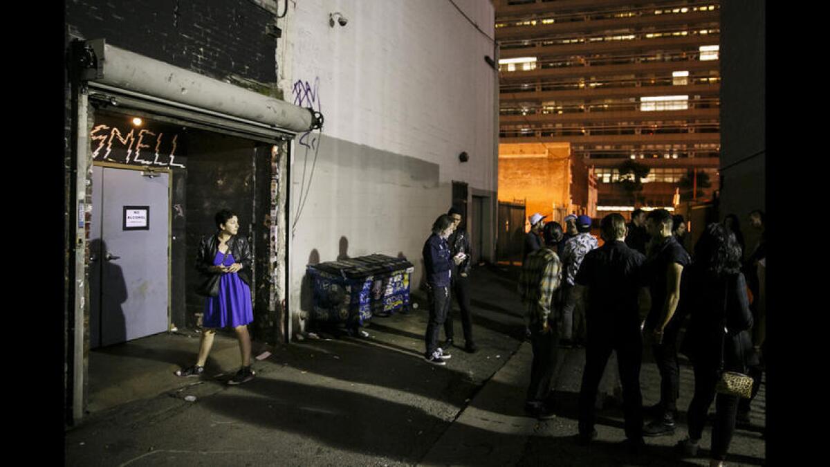 Patrons take a break outside the alleyway entrance at the Smell in downtown Los Angeles.