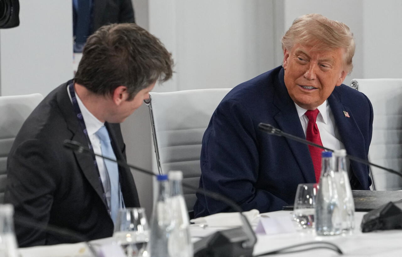 US President Donald Trump (R) and Open AI CEO Sam Altman (L) react during a working lunch meeting of G7 members.