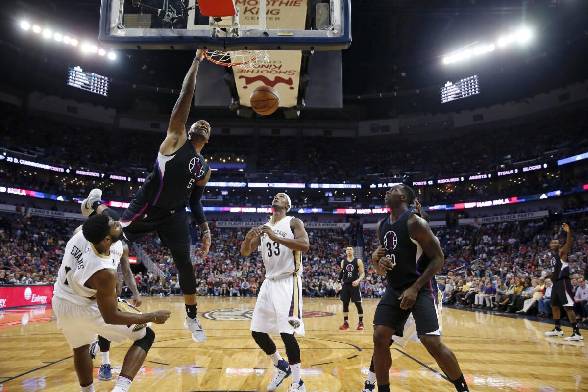 Clippers center Marreese Speights (5) dunks over New Orleans Pelicans guard Tyreke Evans and forward forward Dante Cunningham (33) on Wednesday.