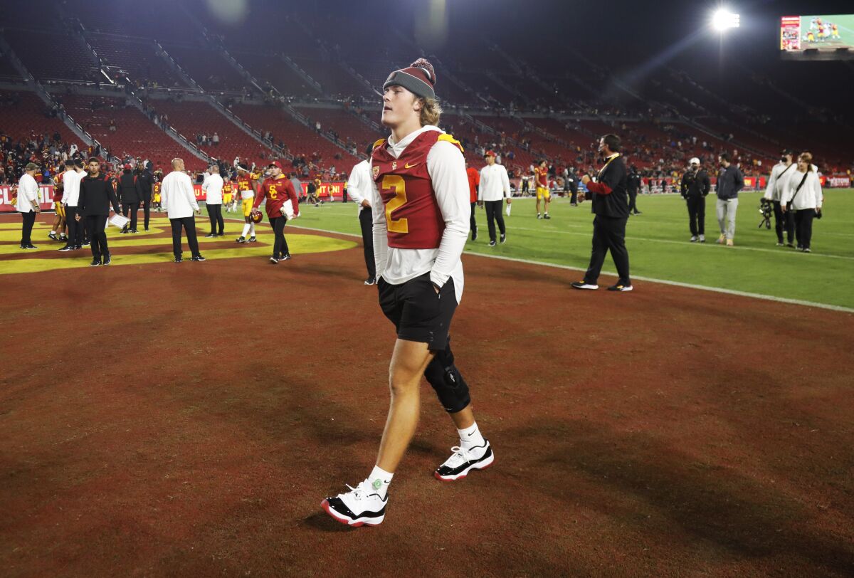 Injured USC Trojans quarterback Jaxson Dart walks off the field at the Coliseum