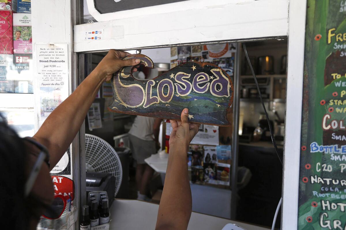 Alizabeth Arciniaga, owner of the Stand Natural Foods, closes shop for the day on Wednesday.