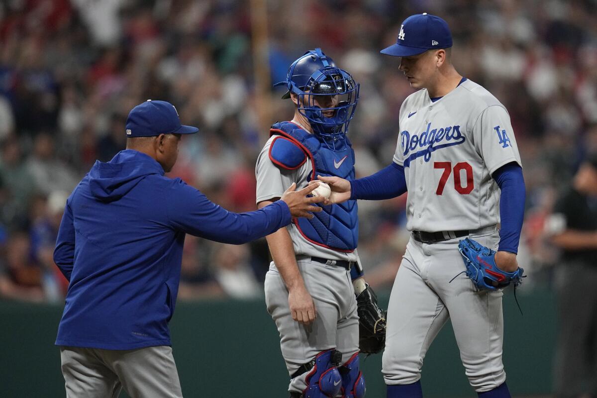 Dodgers' Bobby Miller gives the ball to manager Dave Roberts as he is removed against Cleveland on Aug. 22, 2023.