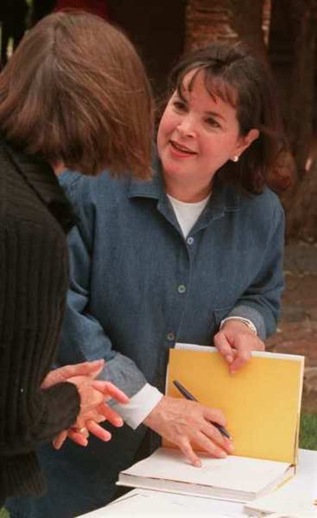 Ina Garten, star of TV's "The Barefoot Contessa," signs one of her cookbooks for a fan.