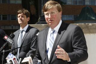 Gov. Tate Reeves speaks to reporters clarifying his earlier issued executive order regarding COVID-19 issues, during a news conference outside the Governor's Mansion, Thursday, March 26, 2020 in Jackson, Miss. (AP Photo/Rogelio V. Solis)