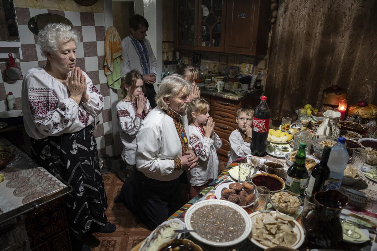 The Zelenchuk family prays before a Christmas dinner in Kryvorivnia village, Ukraine, on Sunday.