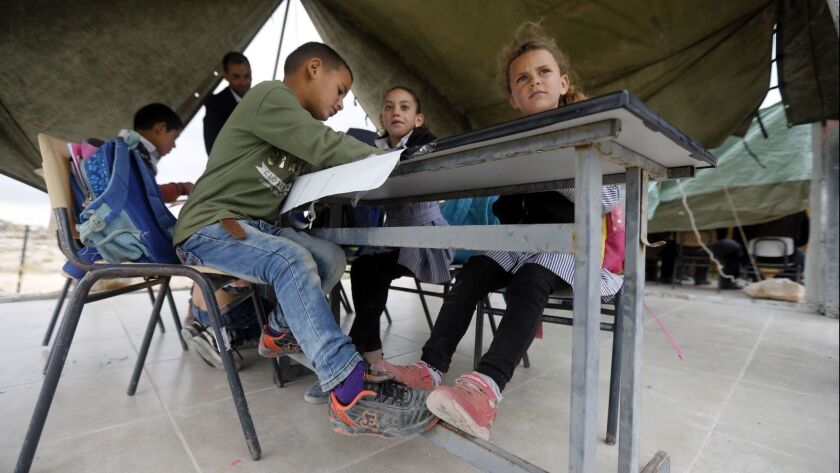 Palestinian school students study inside tents used as a makeshift school in the West Bank village of Zanota.