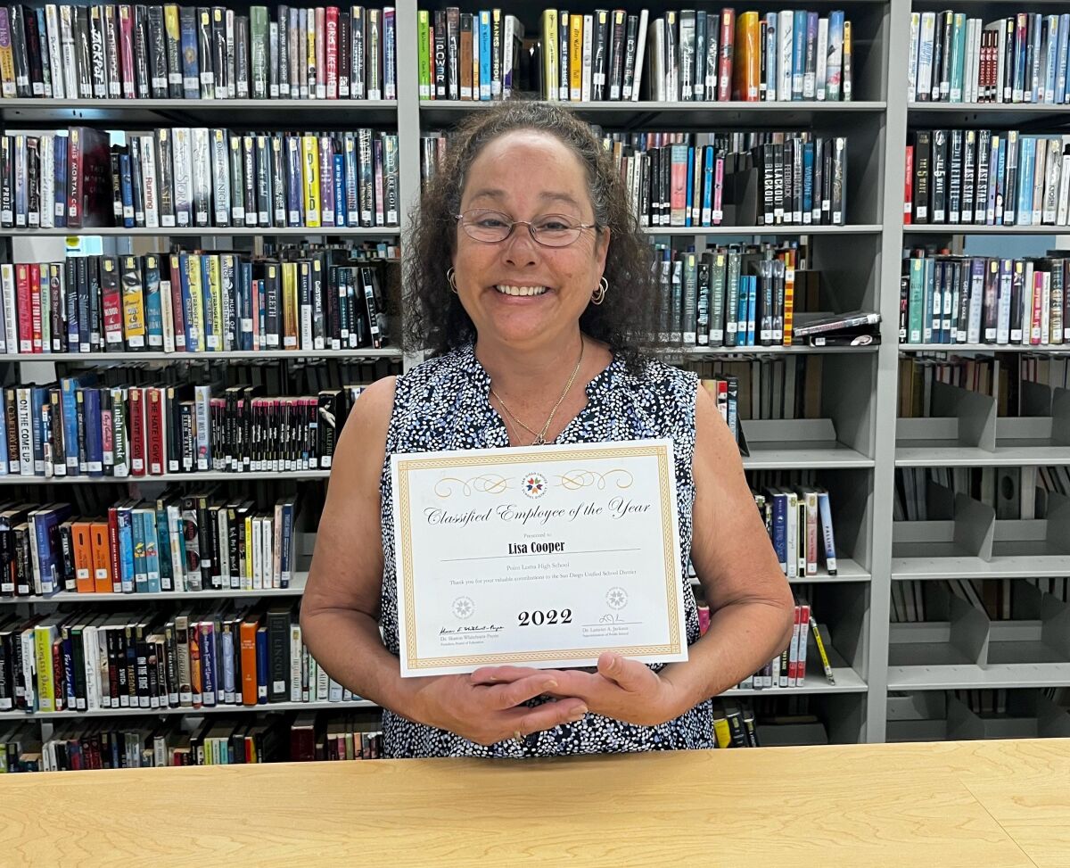 Point Loma High School library technician Lisa Cooper proudly displays her Classified Employee of the Year award.