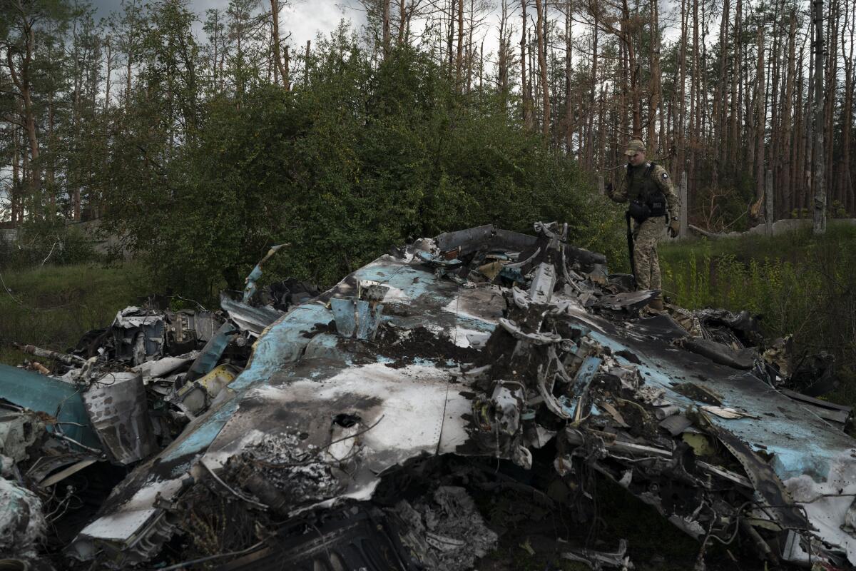 Un soldado ucraniano pasa junto a los restos de un avión ruso SU-34 cerca de la ciudad 