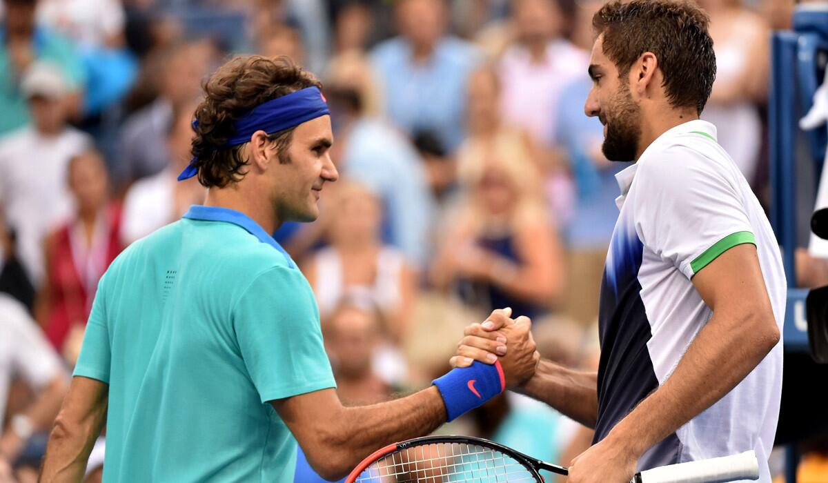Roger Federer, left, congratulates Marin Cilic, who won their U.S. Open semifinal in three sets on Saturday in New York.