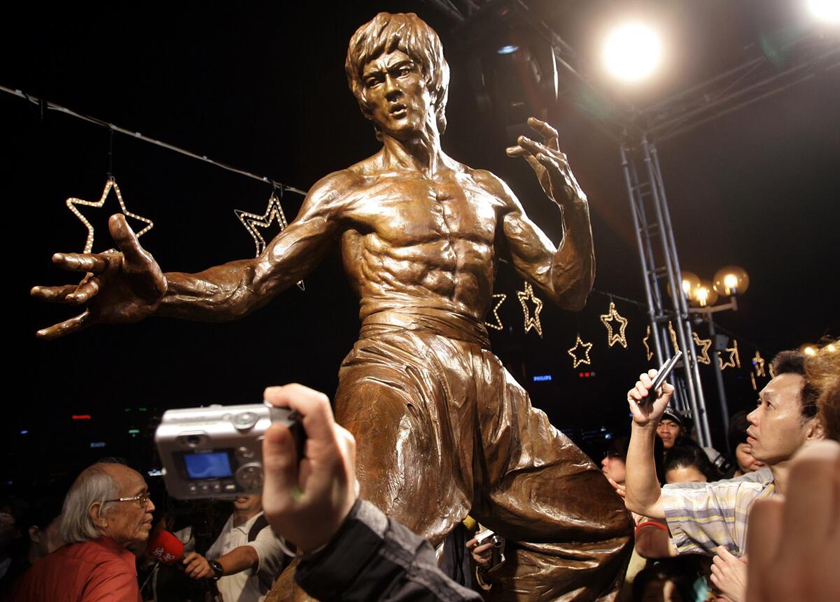 Fans take pictures of a statue of late martial arts legend Bruce Lee in Hong Kong