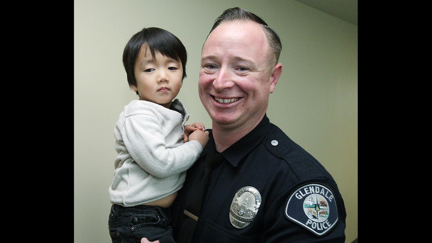 For a while, Glendale Police Officer James Colvin had to chase and keep up with the antics of 3-year-old Clayton Cha, of Glendale at the Glendale Police Department on Thursday, Jan. 22, 2016. Last April, Colvin was the first on the scene to treat then 2-year-old Clayton, who had fallen on his head from 22-feet onto concrete.