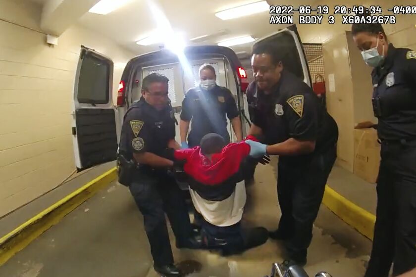 FILE - In this image taken from police body camera video provided by New Haven, Conn., Police, Richard "Randy" Cox, center, is pulled from the back of a police van and placed in a wheelchair after being detained by New Haven Police on June 19, 2022, in New Haven, Conn. The City of New Haven fired two police officers Wednesday, June 7, 2023, for what authorities called their reckless actions and lack of compassion toward Cox, who was injured and became paralyzed in the back of a police van after his arrest last year. (New Haven Police via AP, File)