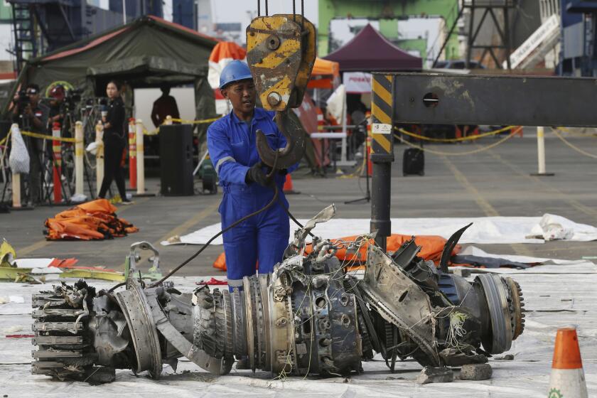 FILE - In this Nov. 4, 2018 file photo, officials move an engine recovered from the crashed Lion Air jet for further investigation in Jakarta, Indonesia. The brand new Boeing 737 MAX 8 jet plunged into the Java Sea just minutes after takeoff from Jakarta early on Oct. 29, killing all of its passengers on board. The FAA's oversight duties are coming under greater scrutiny after deadly crashes involving Boeing 737 Max jets owned by airlines in Ethiopia and Indonesia, killing a total of 346 people. (AP Photo/Achmad Ibrahim, File)