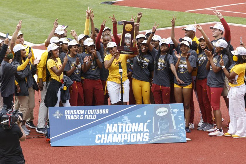 The USC women's track and field team accepts the team trophy after winning the NCAA championship Saturday in Eugene, Ore.