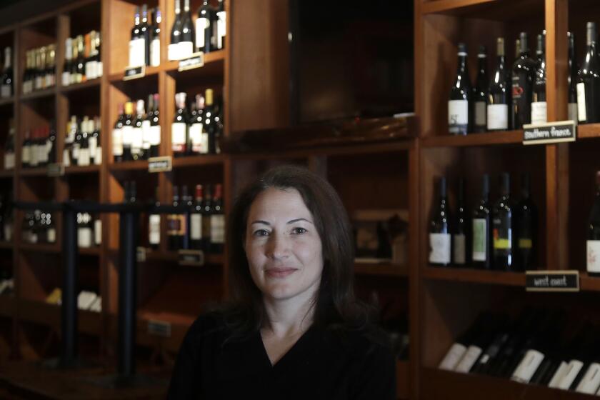 Sarah Trubnick, owner of The Barrel Room, poses for photos while interviewed at the restaurant during the coronavirus pandemic in San Francisco, Tuesday, July 14, 2020. The Barrel Room, a San Francisco wine bar and restaurant, cautiously reopened this month, hoping to salvage as much of 2020 as possible. But as infections climb, Trubnick isn’t taking anything for granted. “We are prepared at any minute to close again,’’ she said. “It’s a very stressful situation.’’ (AP Photo/Jeff Chiu)