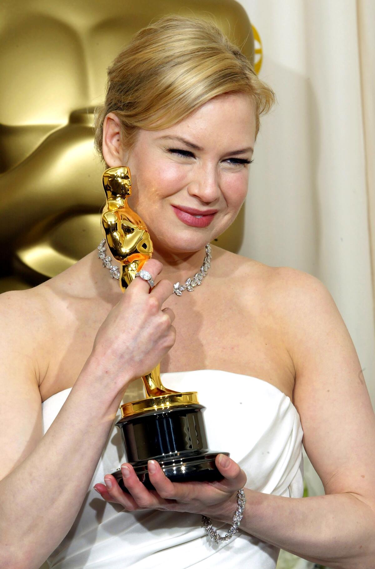 Renee Zellweger poses with her Oscar in a strapless gown in 2004. 