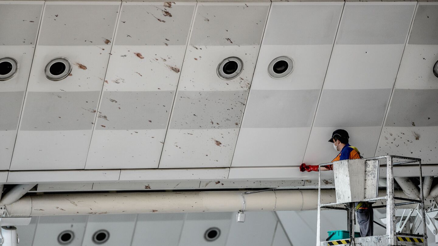 A worker cleans blood stains on the ceiling of the international departure terminal at the country's largest airport, Istanbul Ataturk, following Tuesday's attack in Istanbul, Turkey.