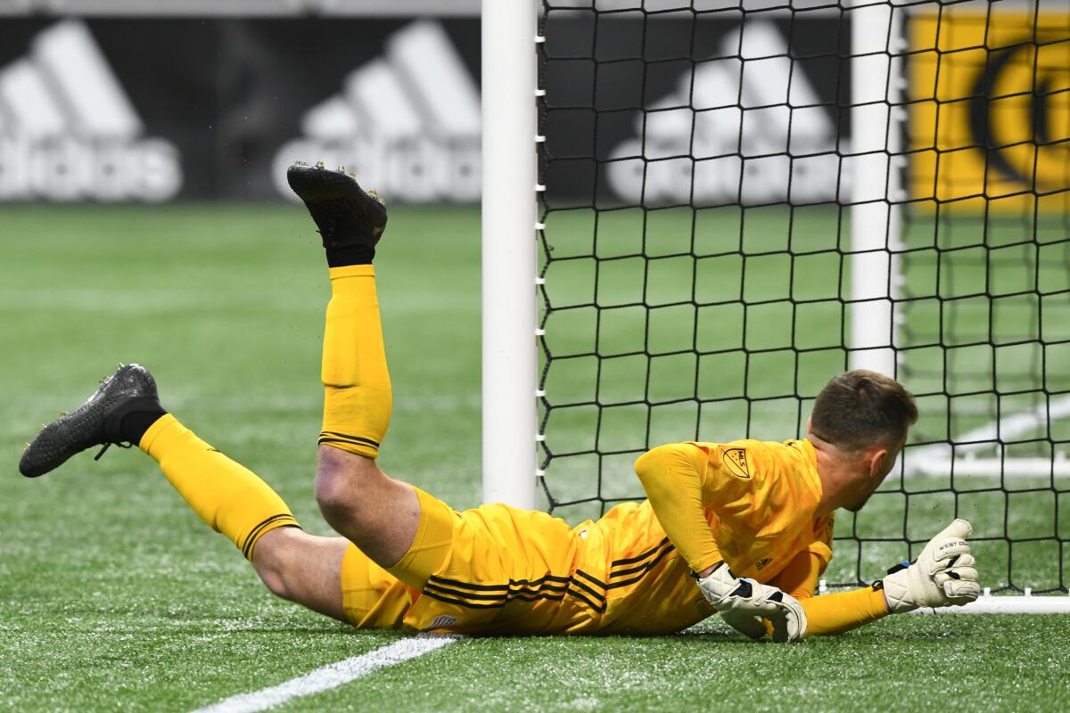 New England Revolution goalkeeper Matt Turner tries to stop a kick on goal by Atlanta United defender Franco Escobar who scored during the second half of round one of an MLS Cup playoff soccer game Saturday, Oct. 19, 2019, in Atlanta. Atlanta United won 1-0. (AP Photo/John Amis)