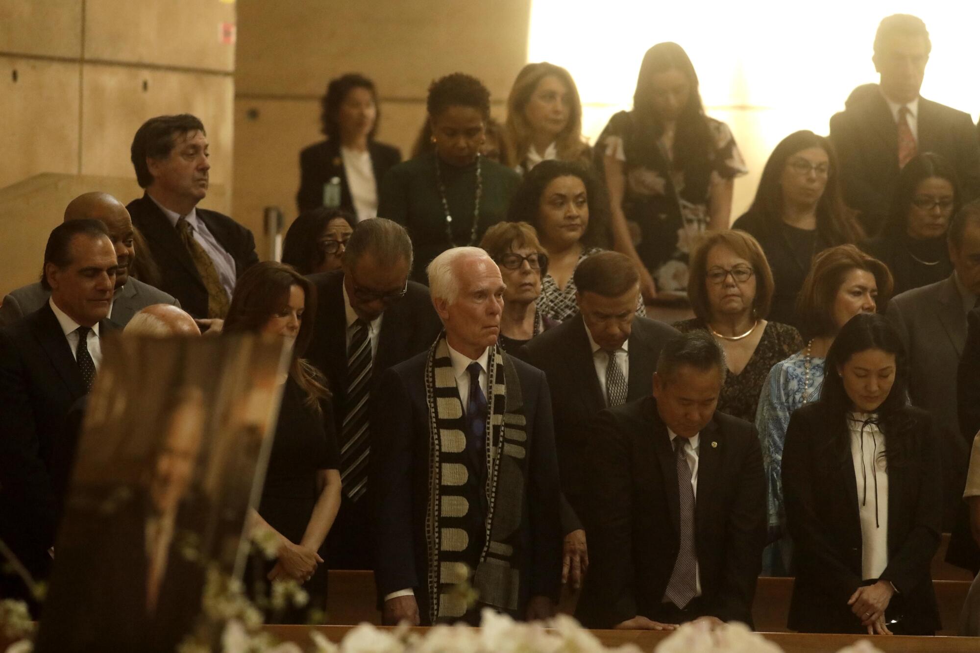 Current and former L.A. politicians stand behind a portrait of Richard Riordan during his memorial Mass.