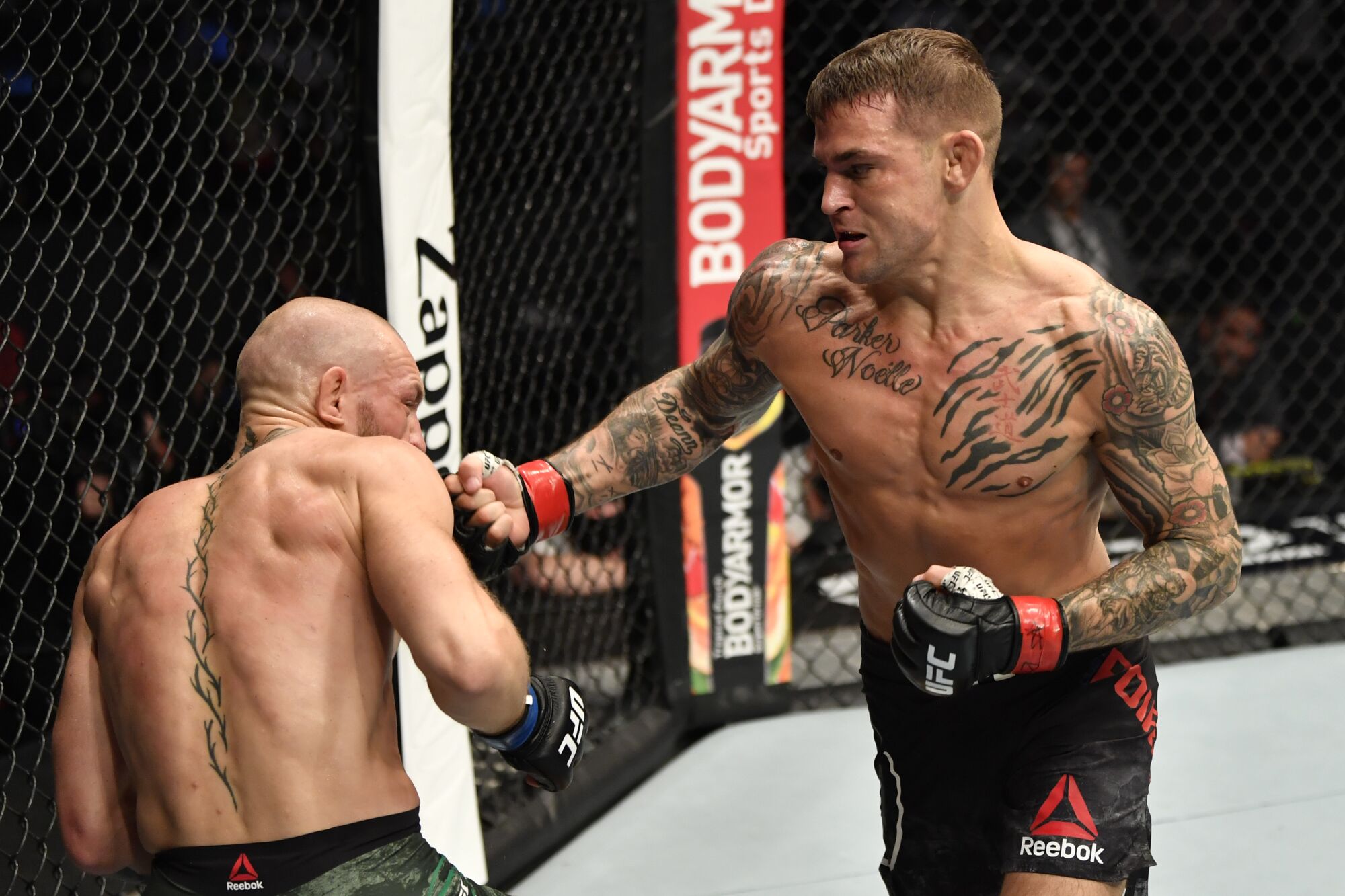 Dustin Poirier punches Conor McGregor during their lightweight fight at UFC 257 in Abu Dhabi on Saturday.