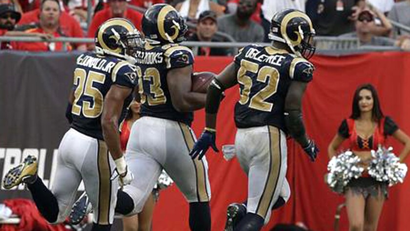Rams defensive tackle Ethan Westbrooks is escorted into the end zone by teammates Alec Ogletree, right, and TJ McDonald Jr. after returning a Buccaneers fumble 77 yards.