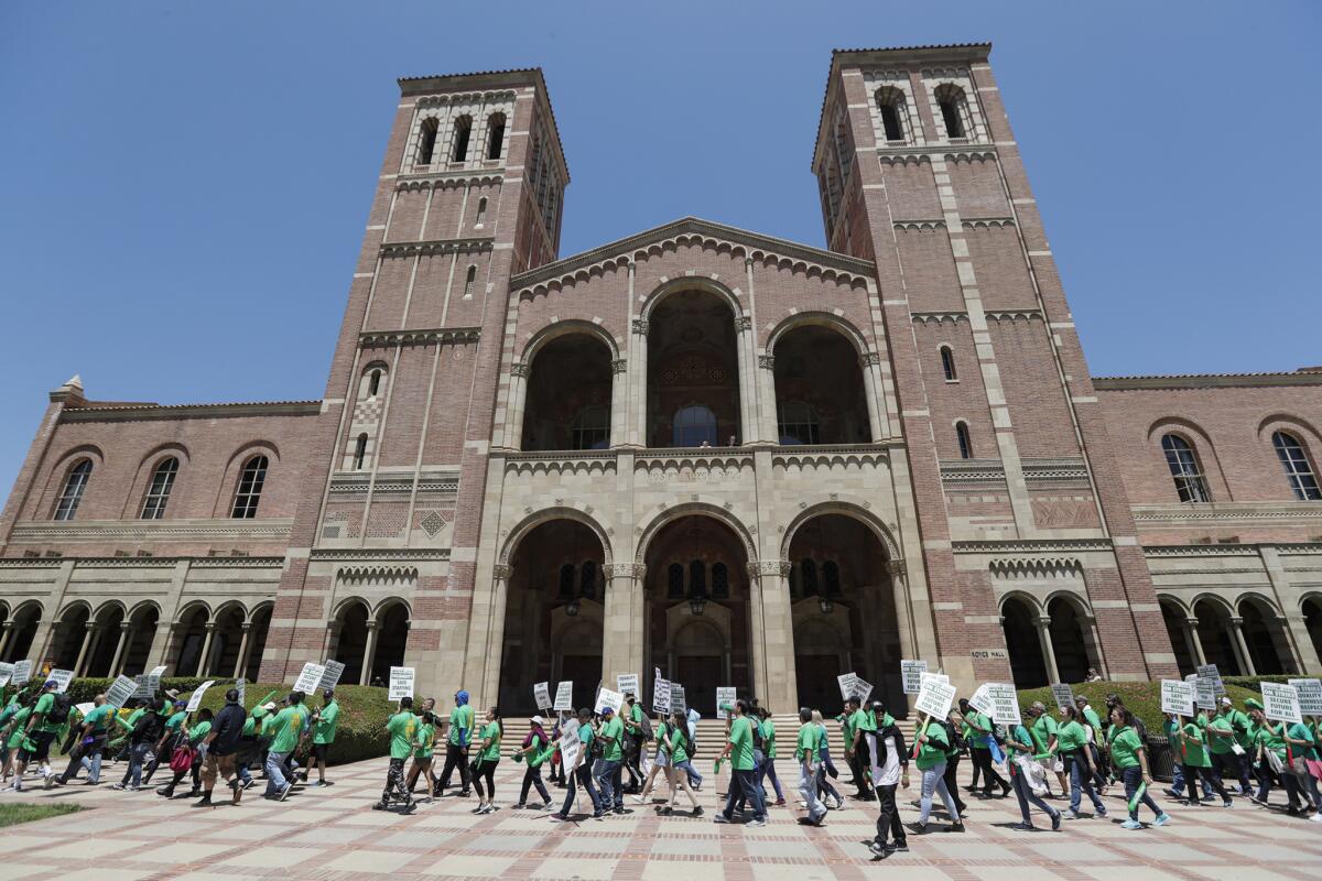 Striking workers march past Royce Hall at UCLA.