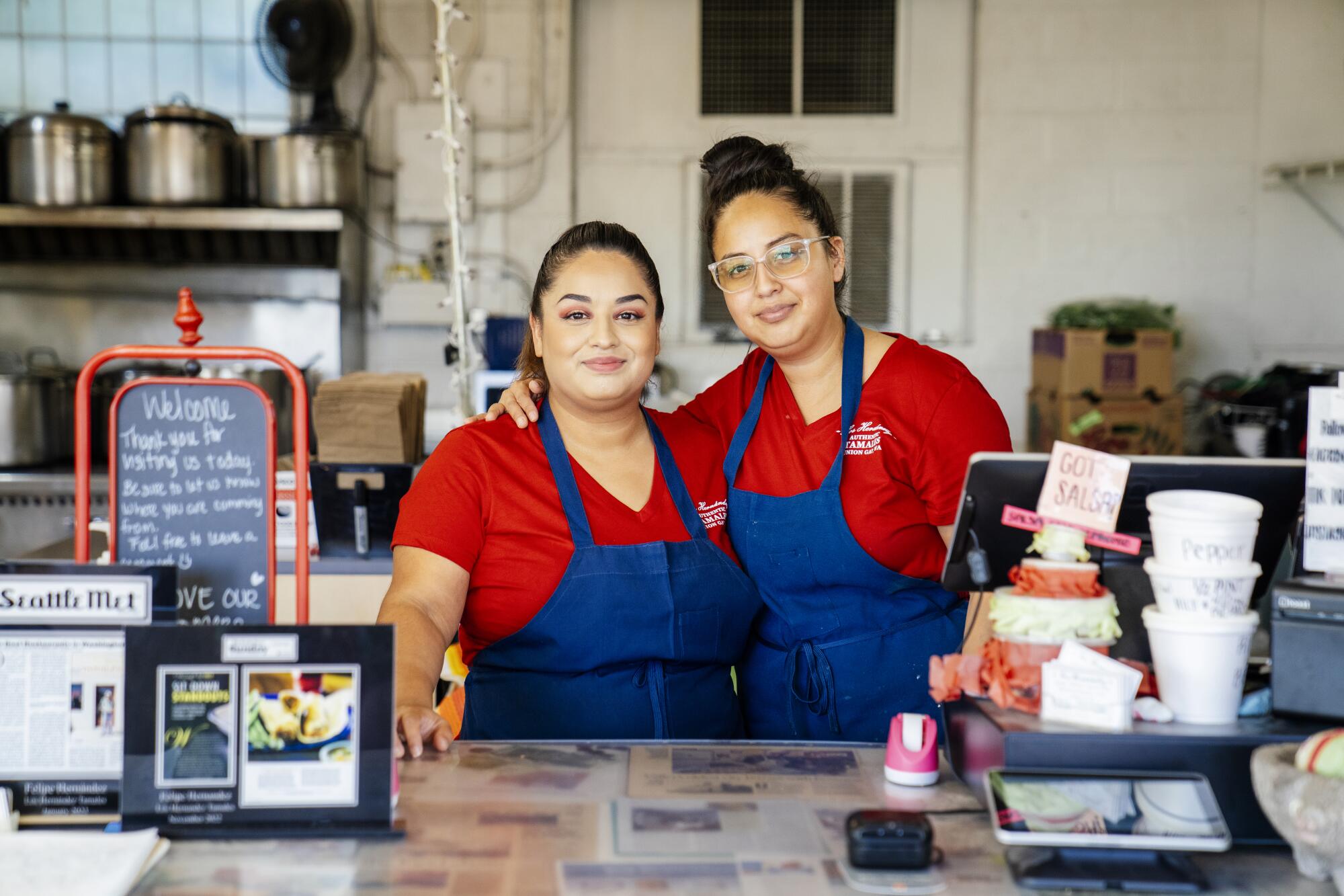 Two woman stand being the counter