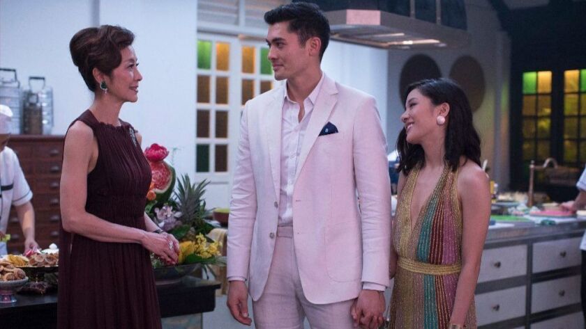 This image released by Warner Bros. Entertainment shows Michelle Yeoh, left, Henry Golding and Constance Wu in a scene from the film "Crazy Rich Asians," set in Singapore.
