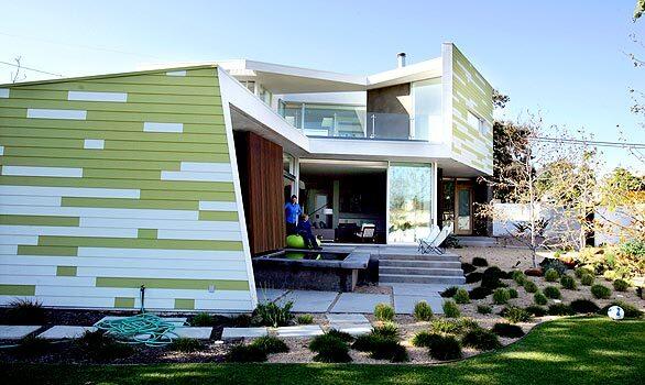 John Friedman Alice Kimm Architects' King house is a striking residence in the Sunset Park neighborhood of Santa Monica. The green and white exterior pattern is designed to mimic the dappled light coming through trees. More important, the architects placed the four-bedroom, four-bath house toward the back of the lot, not only creating a large yard in front but also exposing the heart of the L-shaped home to the neighborhood. "That really confuses people," Erin says. "People come over and ask, ‘Why did your architects take away your backyard?' " For the Kings, the design takes little away. Rather, it gives them a front porch — a patio, actually, that functions as a modern interpretation of the traditional porch.