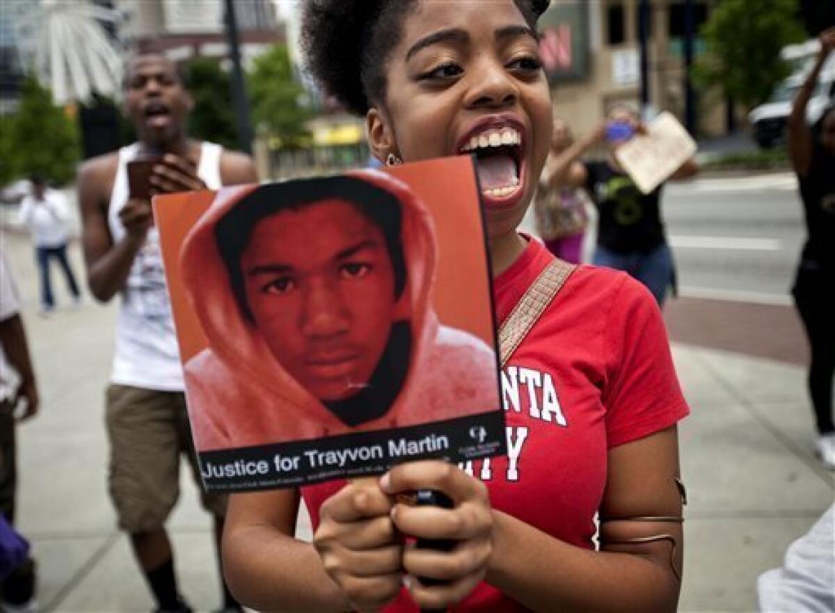 Averri Liggins, 22, of Atlanta holds a photo of Trayvon Martin during a protest the day after George Zimmerman was acquitted of Martin's 2012 slaying.
