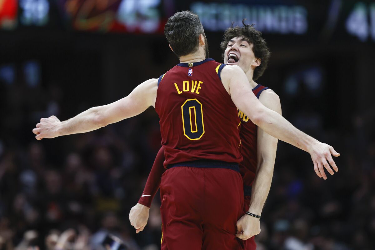 Cleveland Cavaliers' Cedi Osman (16) and Kevin Love (0) celebrate after a basket against the Indiana Pacers during the second half of an NBA basketball game, Sunday, Feb 6, 2022, in Cleveland. (AP Photo/Ron Schwane)