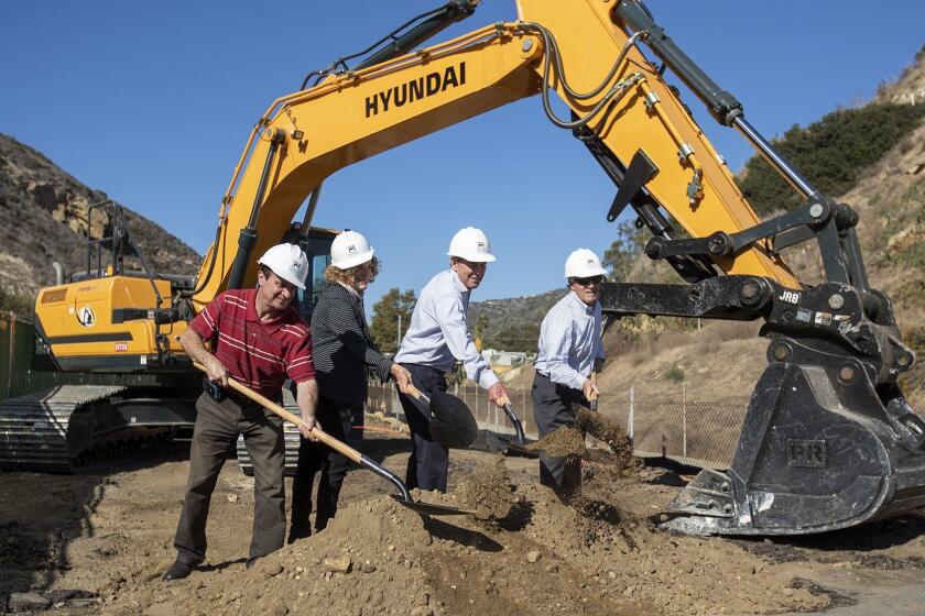 Laguna Beach City Council members Steve Dicterow, left, Toni Iseman, Bob Whalen and Mayor Pro Tem Rob Zur Schmiede toss a shovel full of dirt during a ground-breaking ceremony for the Village Entrance project.