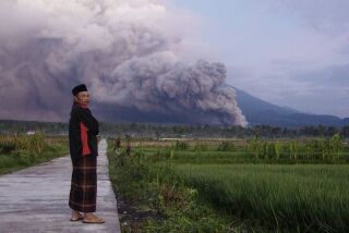 Un hombre mira mientras el monte Semeru expulsa material volcánico durante una erupción el domingo 4 de diciembre de 2022 en Lumajang, Java Oriental, Indonesia. (AP Foto)