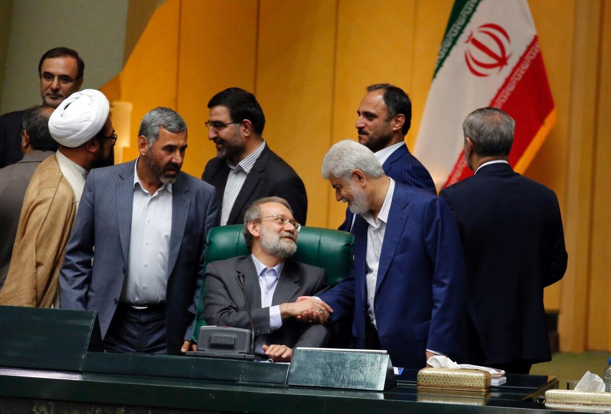 Ali Larijani, center, speaker of the Iranian parliament, is congratulated by fellow members of parliament on his reelection to the post on Sunday.