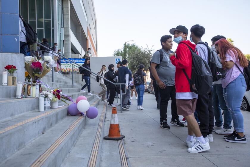 Los Angeles, CA - September 16: Students exit their school and stand next to a memorial on the steps on Friday, Sept. 16, 2022, in the Hollywood neighborhood of Los Angeles, CA. Two high school boys were arrested Thursday, one on suspicion of manslaughter for allegedly selling what is believed to be a fentanyl-laced pill that led to the overdose death of a student at Helen Bernstein High School. Authorities said that the student was found in a bathroom at the Hollywood school this week. (Francine Orr / Los Angeles Times)