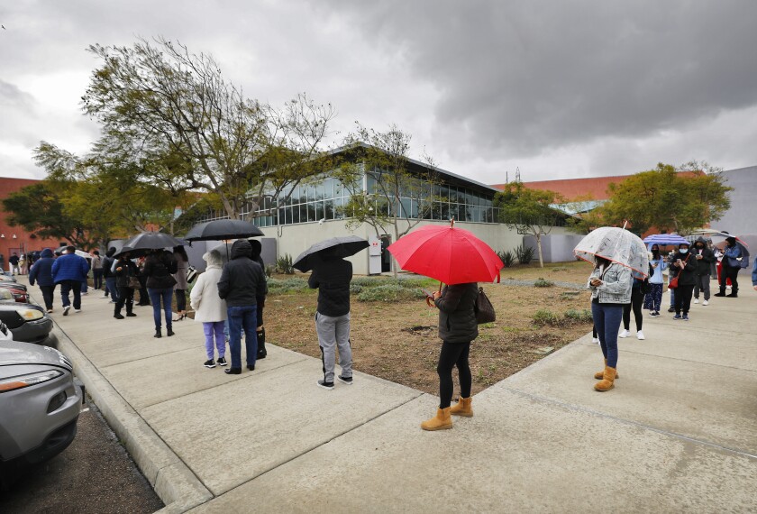 People wait in line to get a COVID-19 test at the South Region Live Well Center in Chula Vista in December.