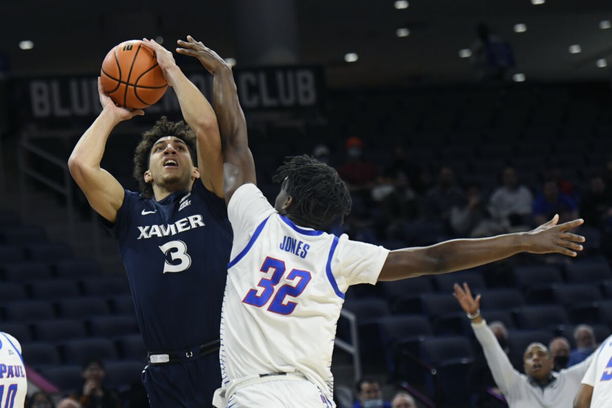 Xavier's Colby Jones (3) goes up for a shot against DePaul's David Jones (32) during the first half of an NCAA college basketball game Wednesday, Jan. 19, 2022, in Chicago. (AP Photo/Paul Beaty)