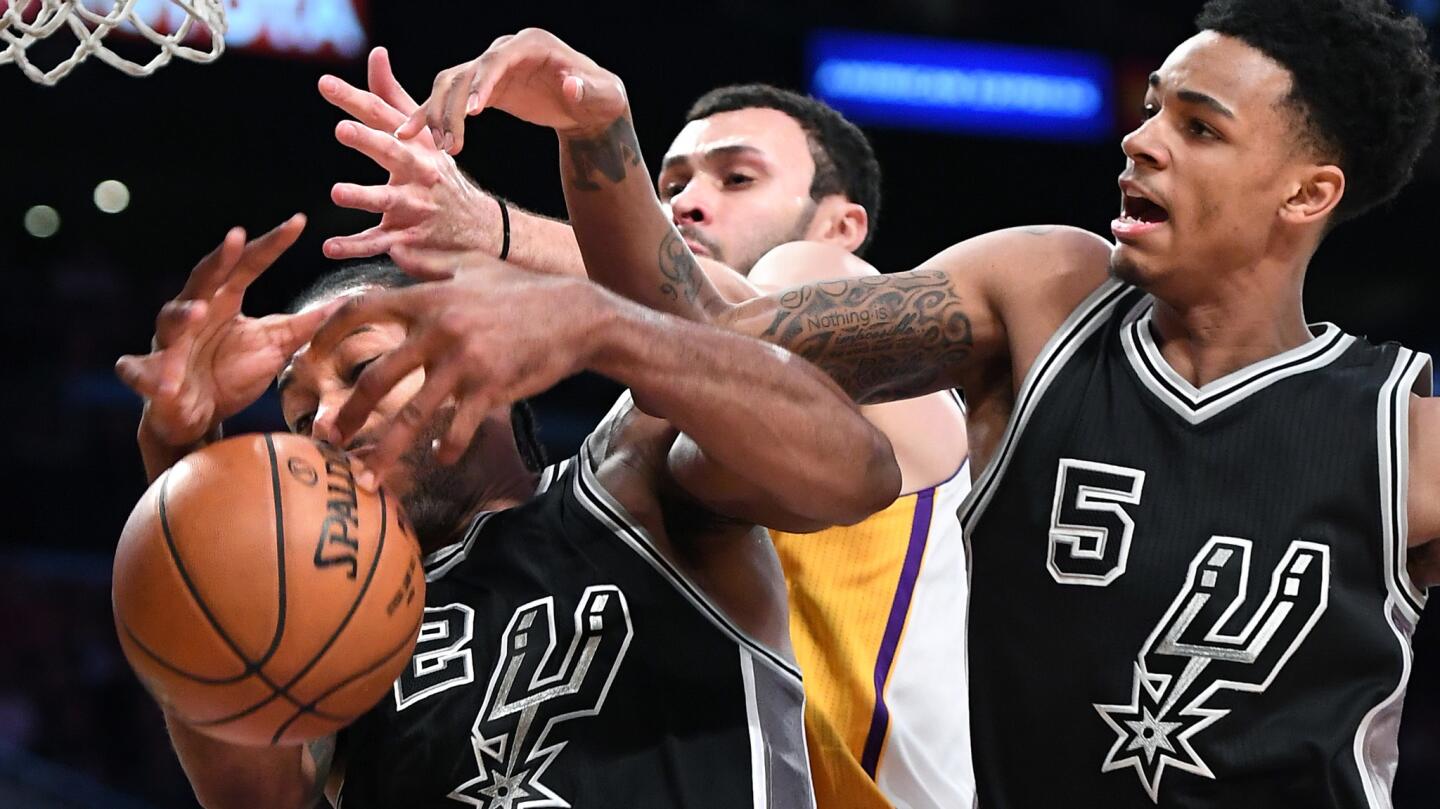 Spurs forward Kawhi Leonard and Dejounte Murray battle for a rebound against Lakers forward Larry Nance Jr. in the fourth quarter.