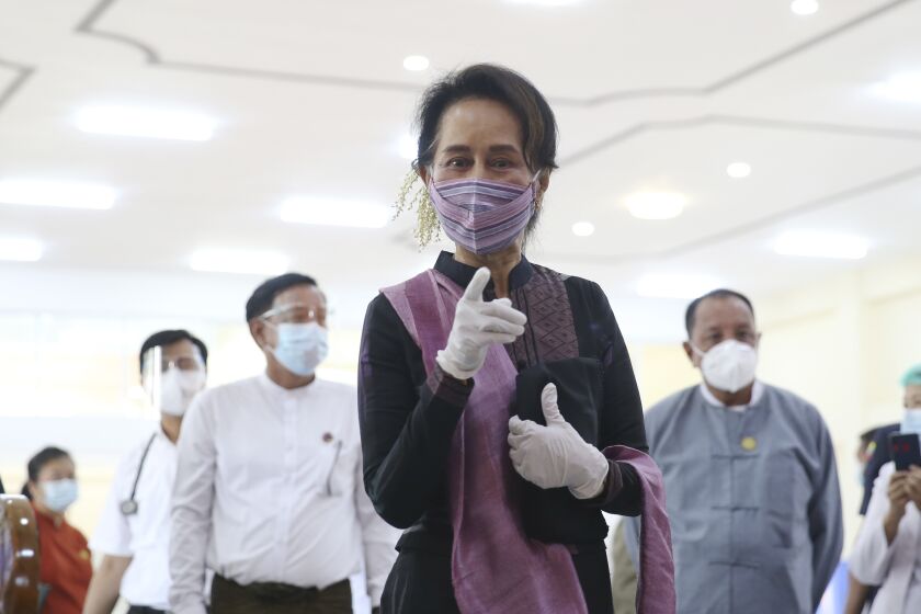 Myanmar leader Aung San Suu Kyi, center, speaks as she inspects the vaccination processes to health workers at hospital Wednesday, Jan. 27, 2021, in Naypyitaw, Myanmar. Health workers in Myanmar on Wednesday became the country's first people to get vaccinated against COVID-19, just five days after the first vaccine supply was delivered from India. (AP Photo/Aung Shine Oo)