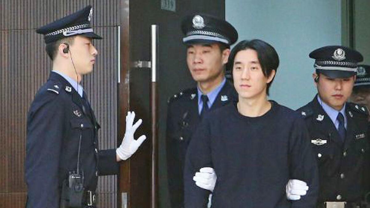 Jaycee Chan, son of Jackie Chan, is escorted into court in Beijing.
