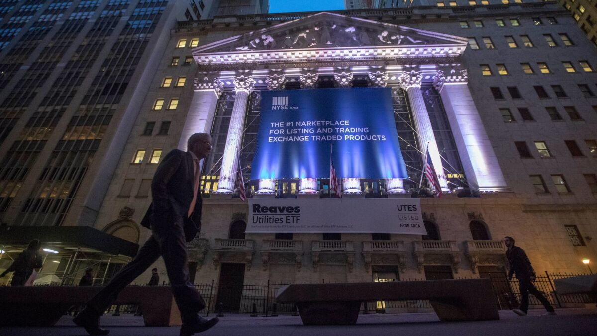 A pedestrian passes the New York Stock Exchange in lower Manhattan, where stocks have risen to record levels since the election.