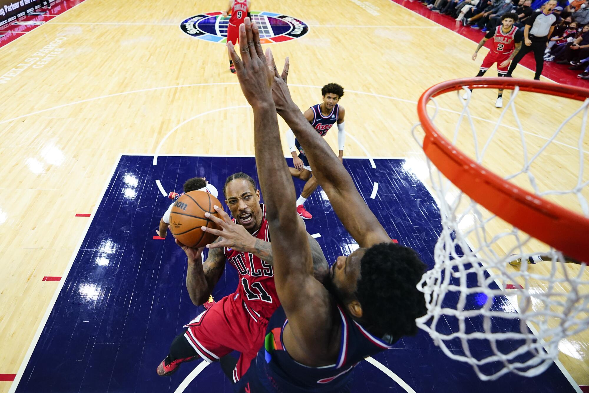 Bulls forward DeMar DeRozan tries to score against 76ers center Joel Embiid.