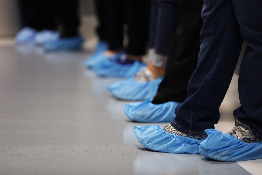 Visitors wear shoe covers during open house of the OneLegacy Redlands Transplant Recovery Center on March 21, 2018. (Christina House / Los Angeles Times)
