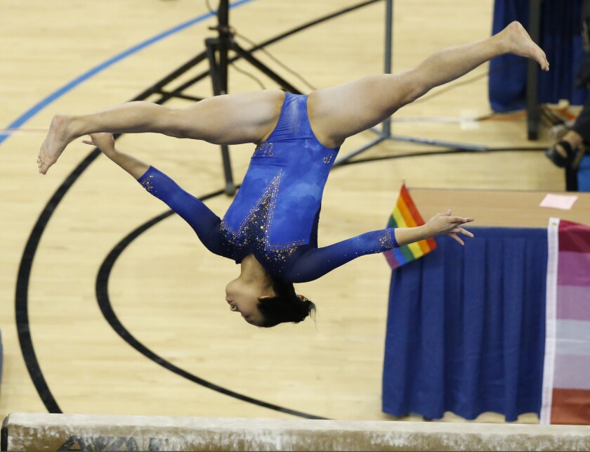  Samantha Sakti competes on the balance beam during a UCLA gymnastics meet.