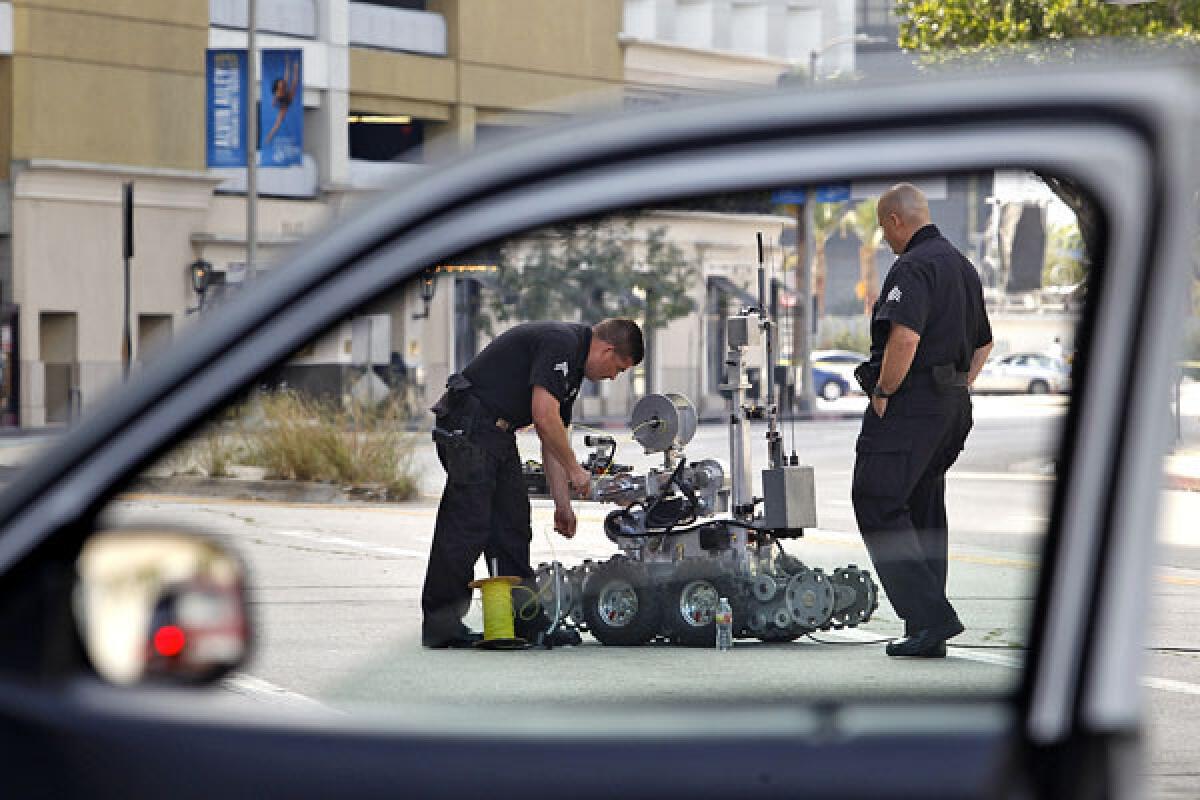 LAPD officers use a robot at the Beverly Center in Los Angeles after the shopping mall was evacuated when a suspicious package was found Sunday in the attached parking garage.